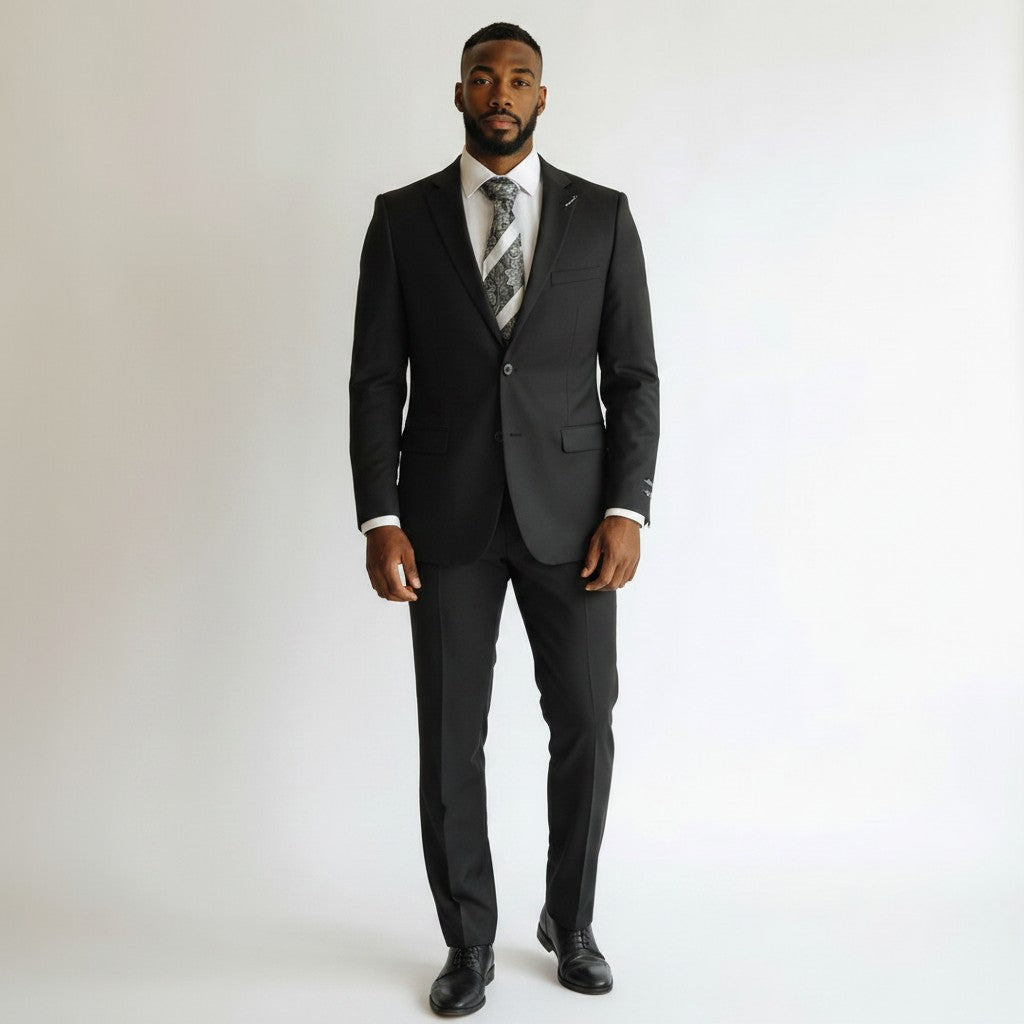 Looking Good Pine Bluff ELEGANZA black suit worn by a man with a white shirt and patterned tie against a white wall